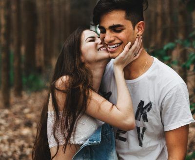 Woman about to kiss man in the forest - happy couple