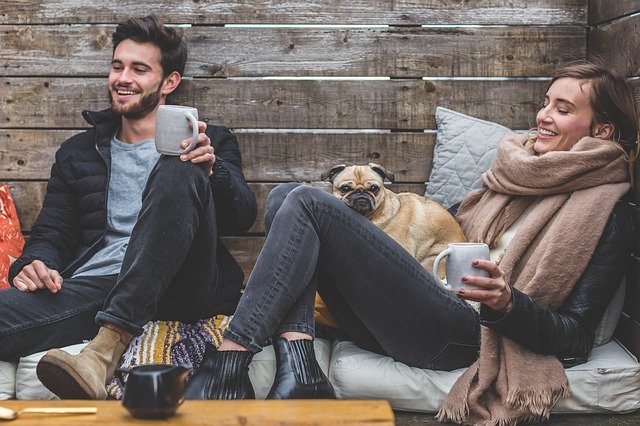 A couple hanging out with their dog outdoor