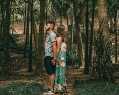 A couple backing each other in the woods