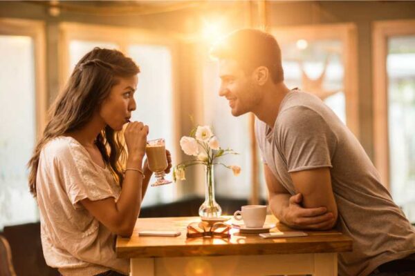 A man and a woman talking in a cafe