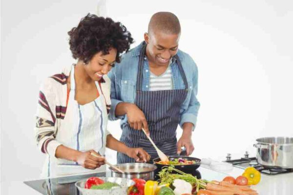 An african american couple cooking at home